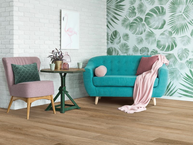 blue couch in living space with leaf wall paper - Home Design of Hastings in Hastings, MN